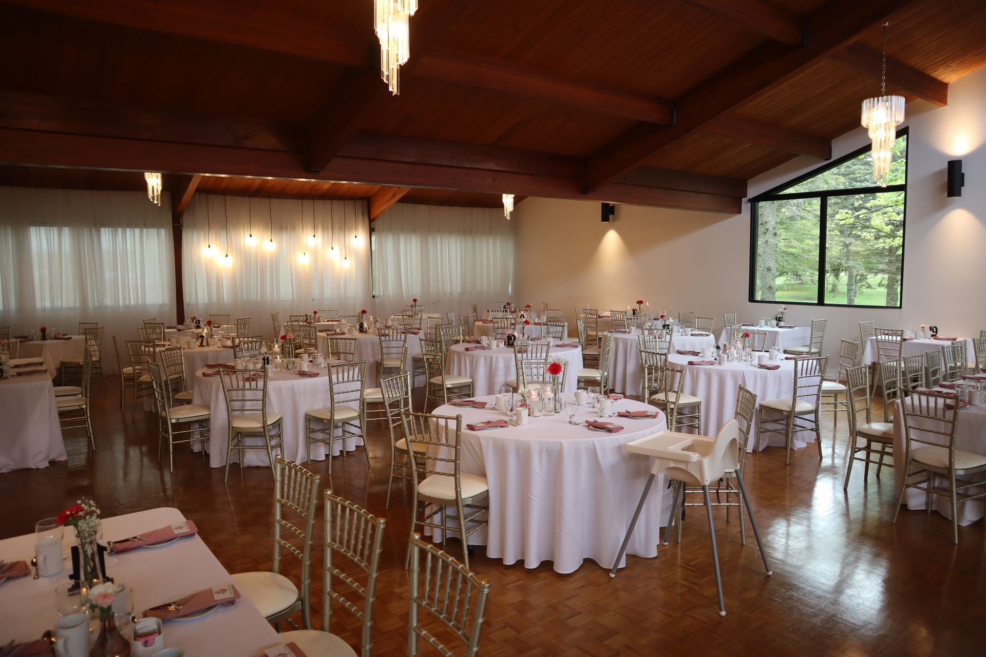 A large room with tables and chairs set up for an event.