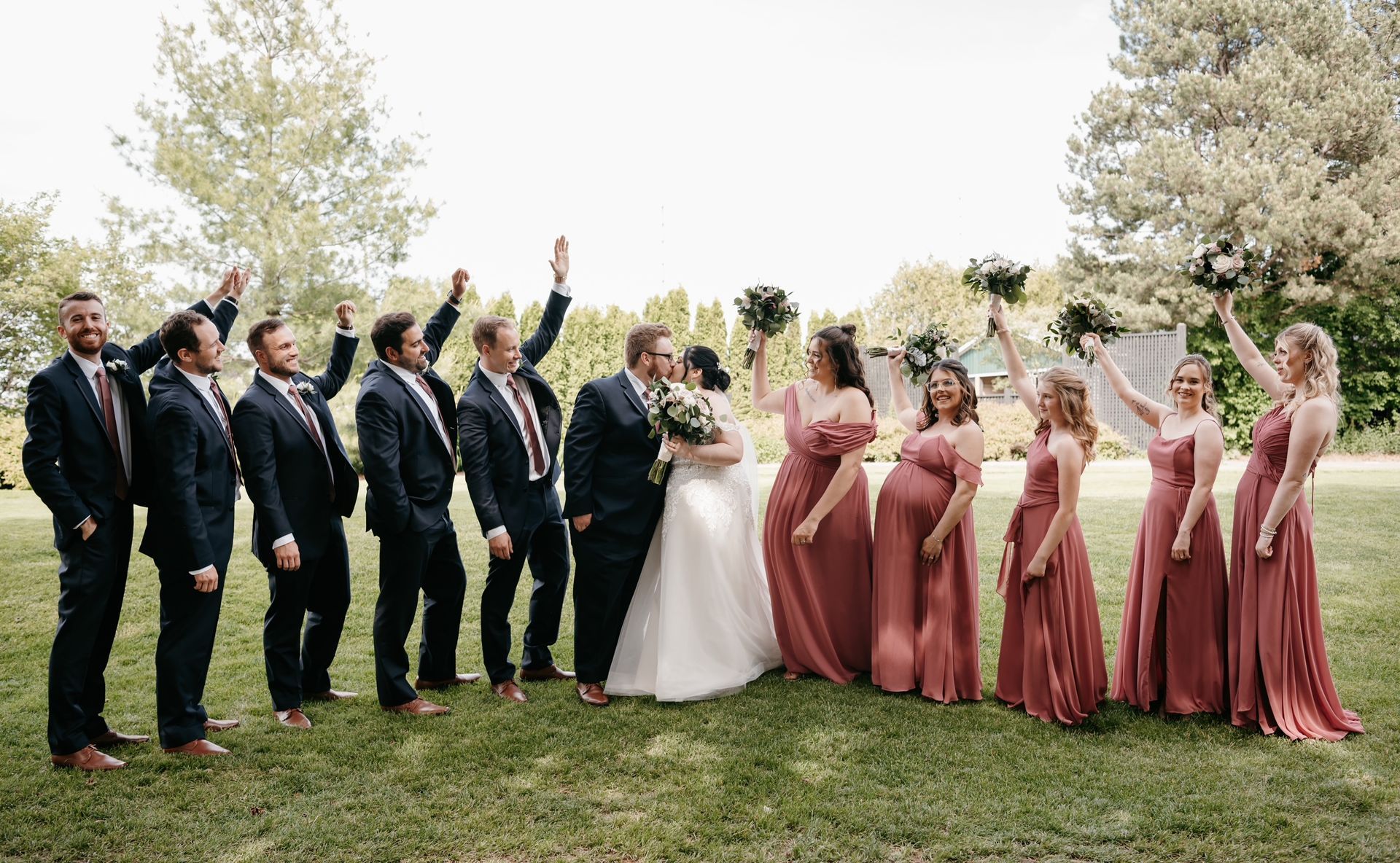 A bride and groom are posing for a picture with their wedding party.