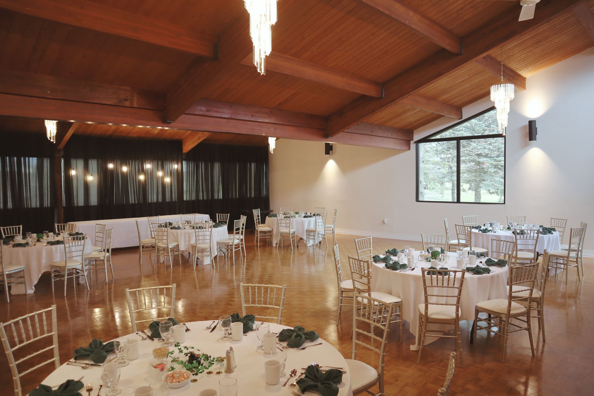 A large room with tables and chairs set up for an event.