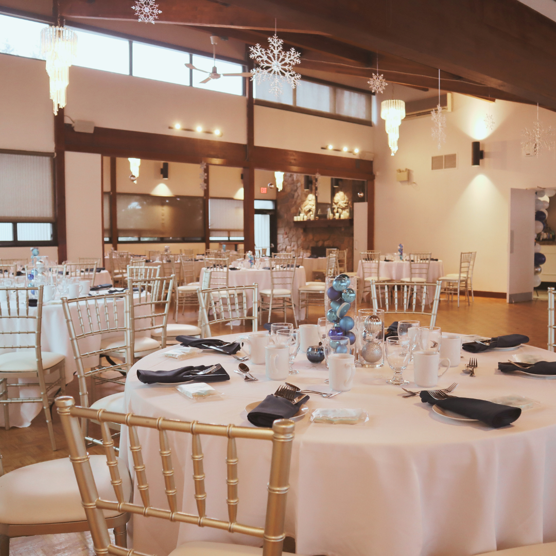 A large room with tables and chairs set up for an event.