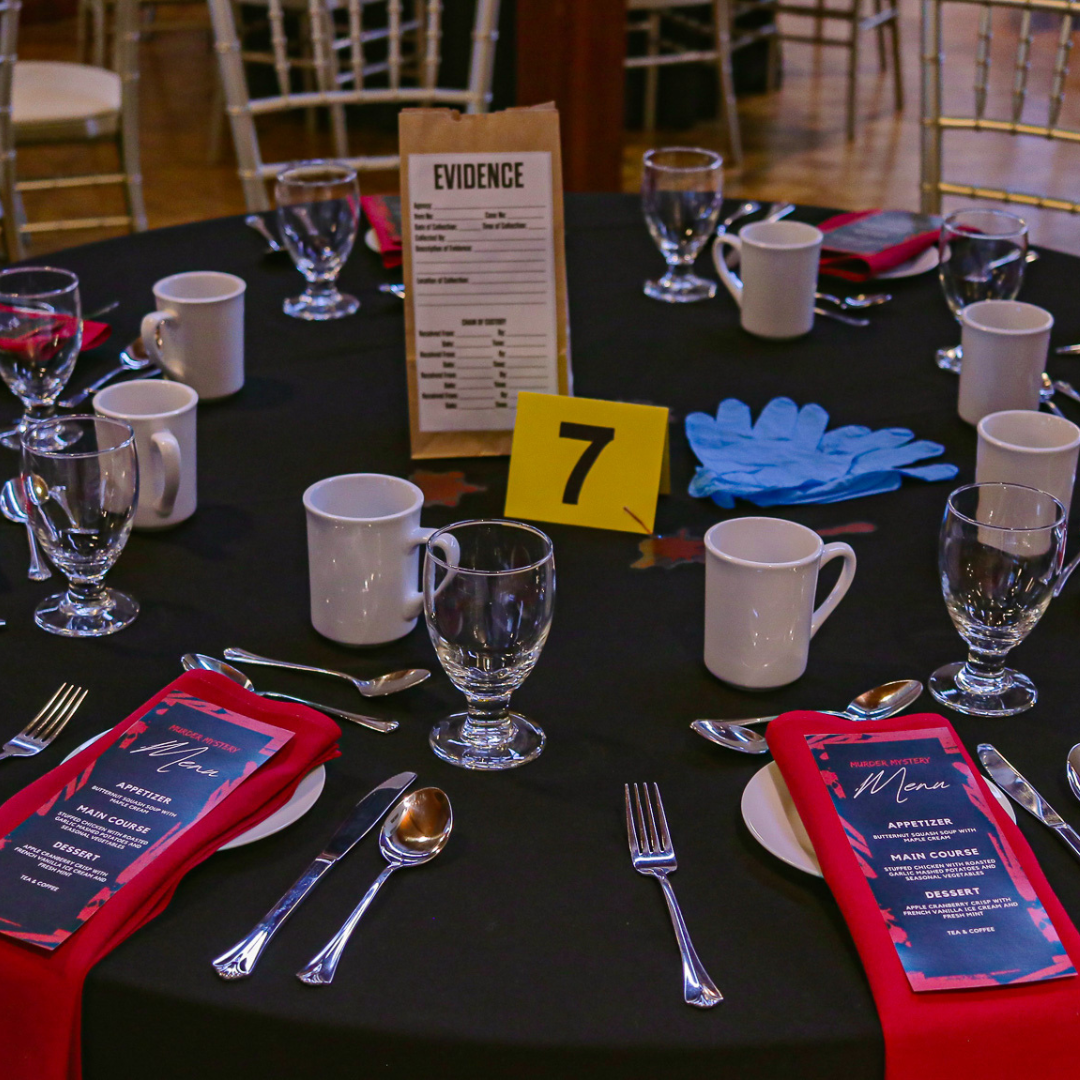 A dinner table with an evidence marker and bag centerpiece for a Murder Mystery event.