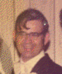 A man, Bryce Brown Jr., wearing glasses and a tuxedo is smiling for the camera.