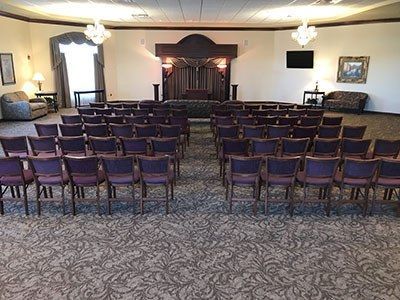a large room filled with rows of purple chairs and a couch.