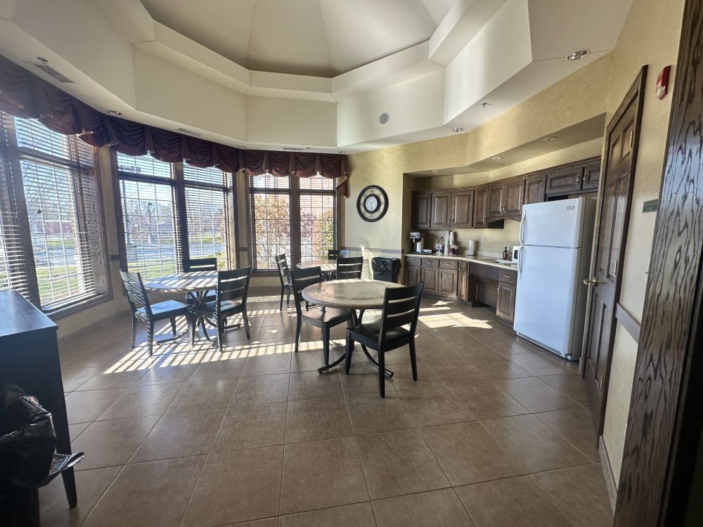 a kitchen with tables and chairs and a refrigerator.