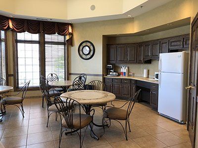 a kitchen with tables and chairs and a refrigerator .