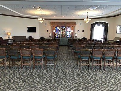 a large room filled with chairs and a stained glass window.