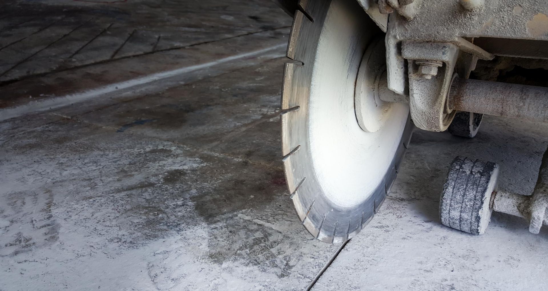 Concrete saw cutting a groove in a concrete surface.