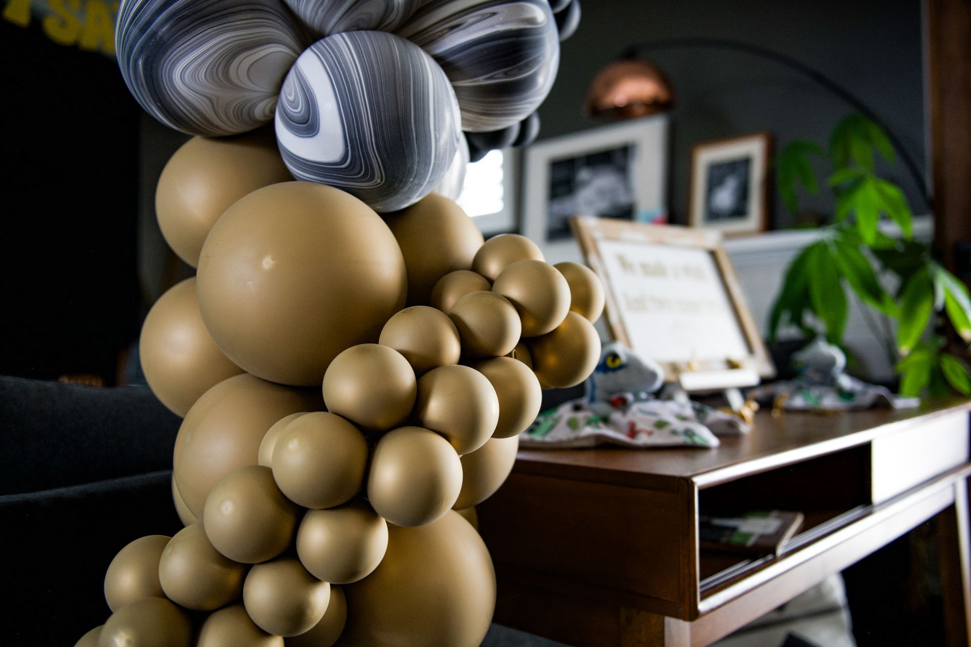A bunch of balloons are sitting on top of a wooden table.