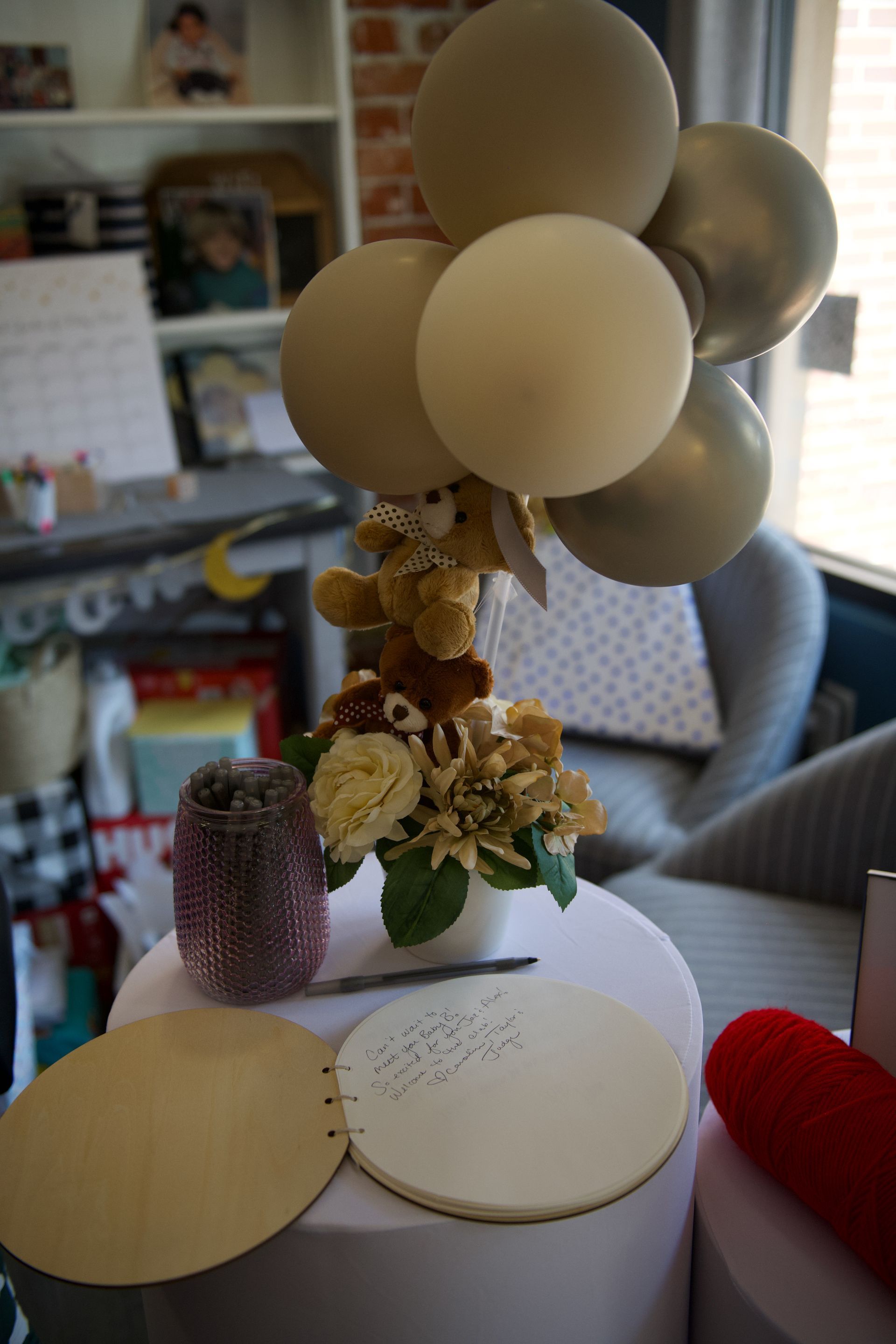 A table with a vase of flowers and balloons on it.