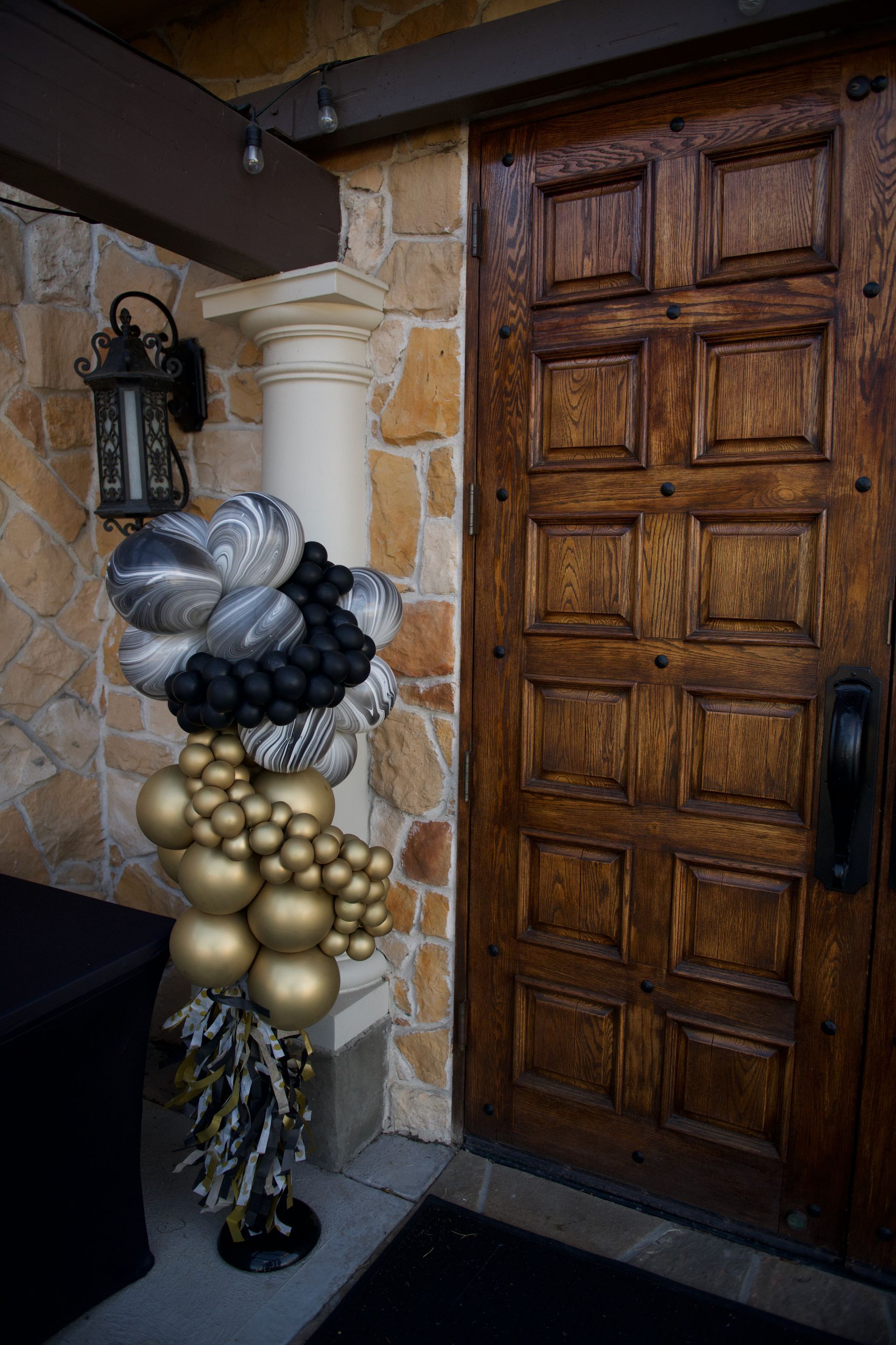 A bunch of balloons are sitting in front of a wooden door.