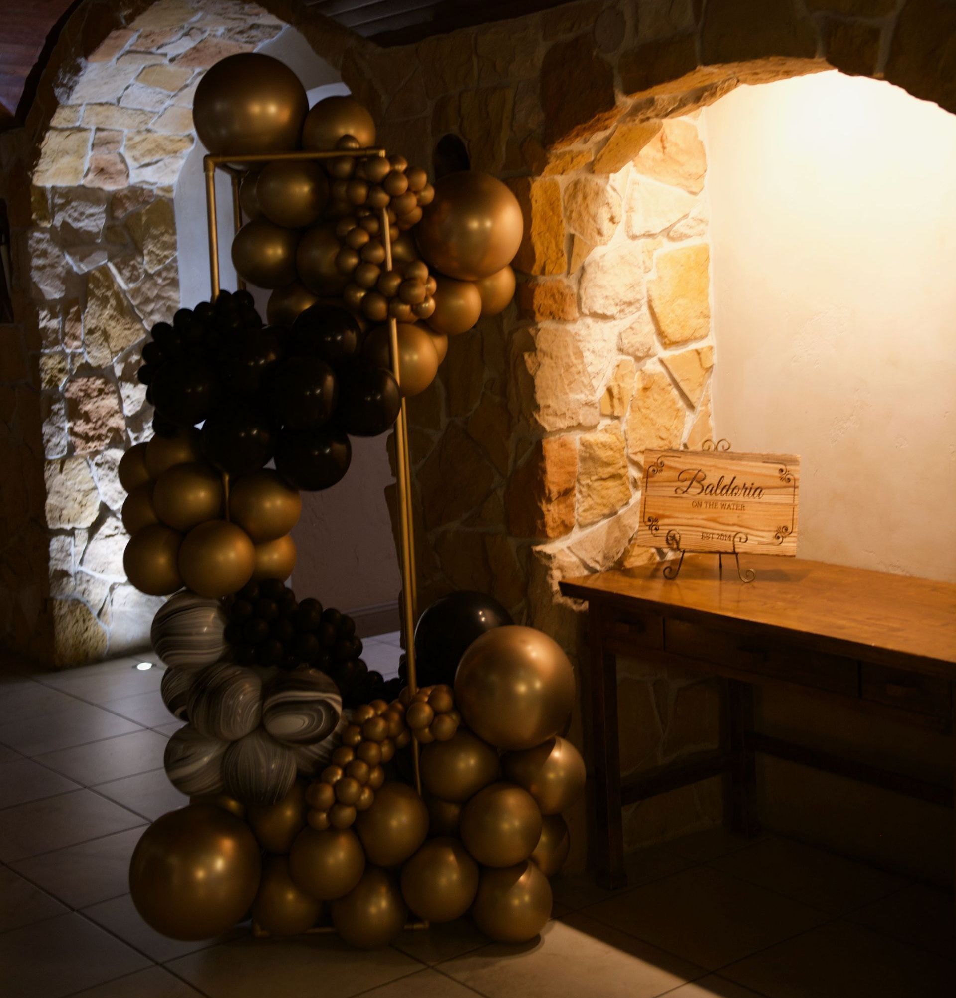 A bunch of balloons are sitting in a room next to a wooden table.