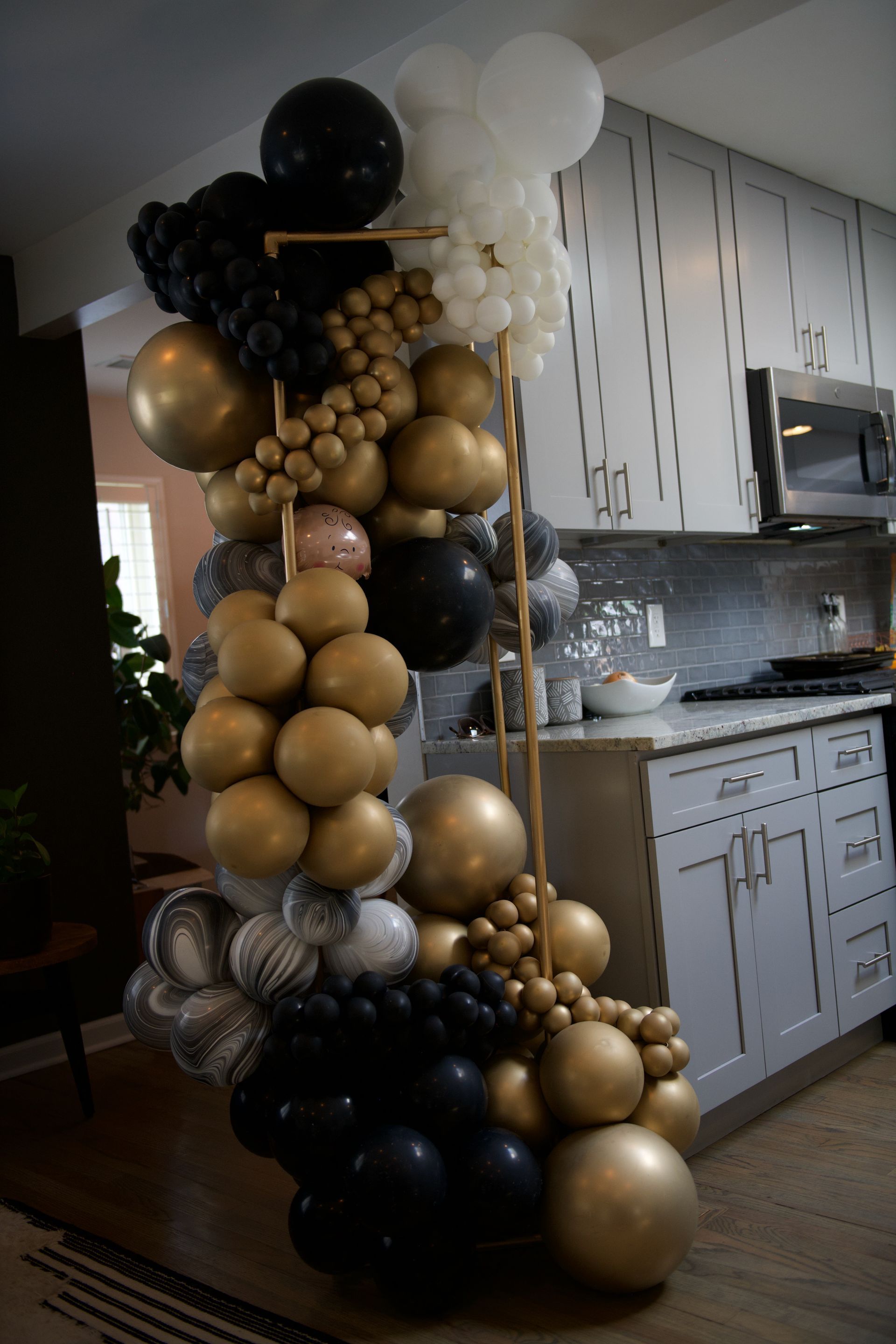 A bunch of balloons are sitting in a kitchen.
