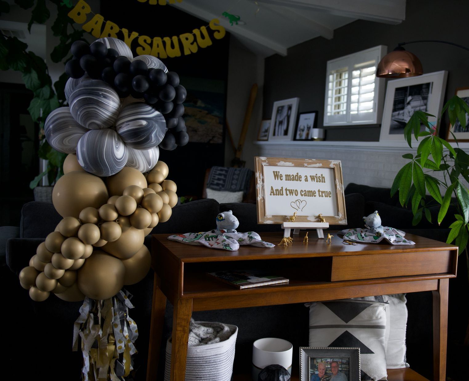A table with balloons and a sign that says babysaurus