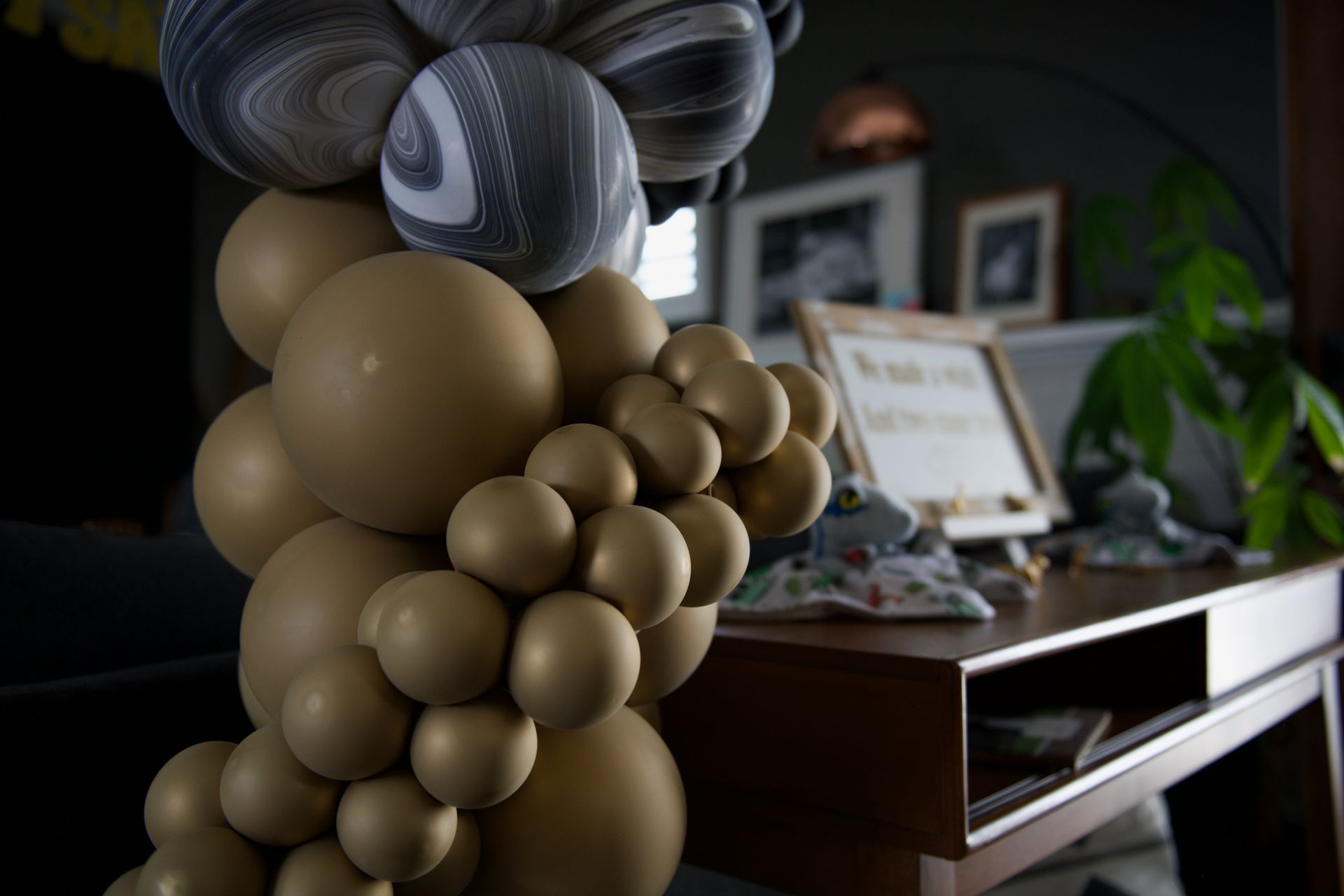 A bunch of balloons are sitting on top of a wooden table.