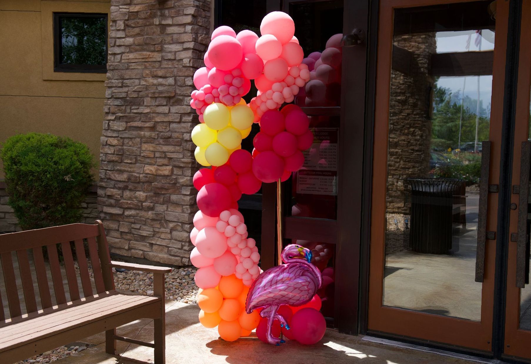 A bunch of balloons are sitting on the ground in front of a building.