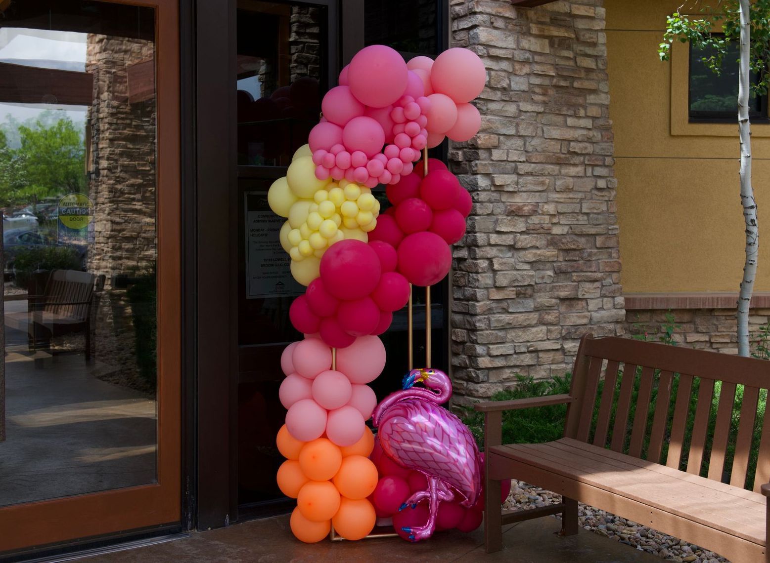 A bunch of balloons are sitting in front of a building.