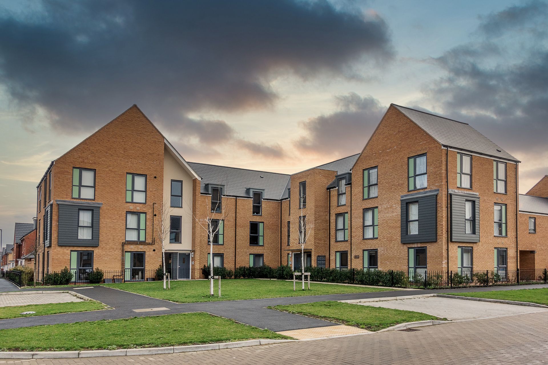 A large brick building with a lot of windows in a residential area.