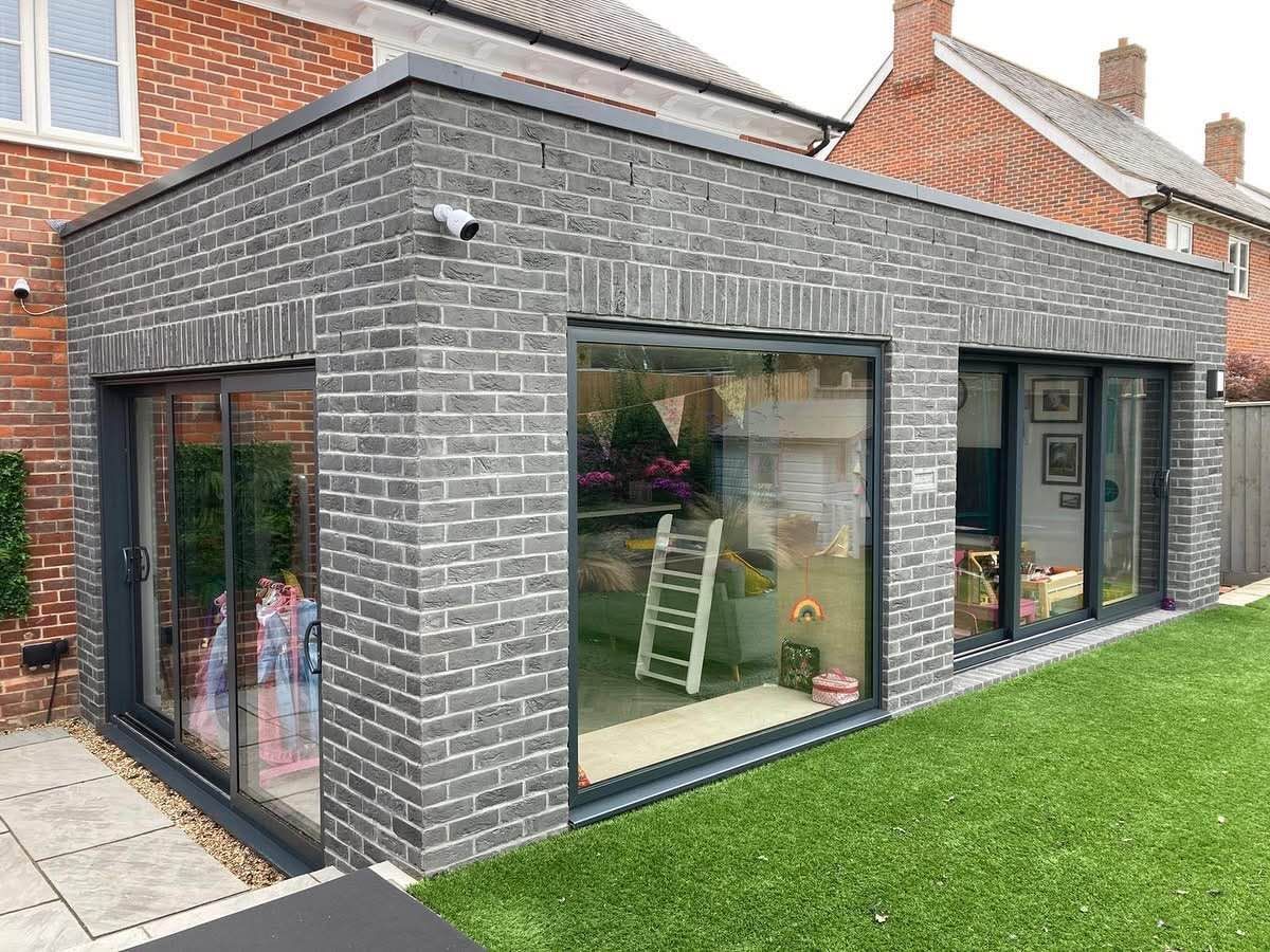 A brick extension to a house with sliding glass doors.