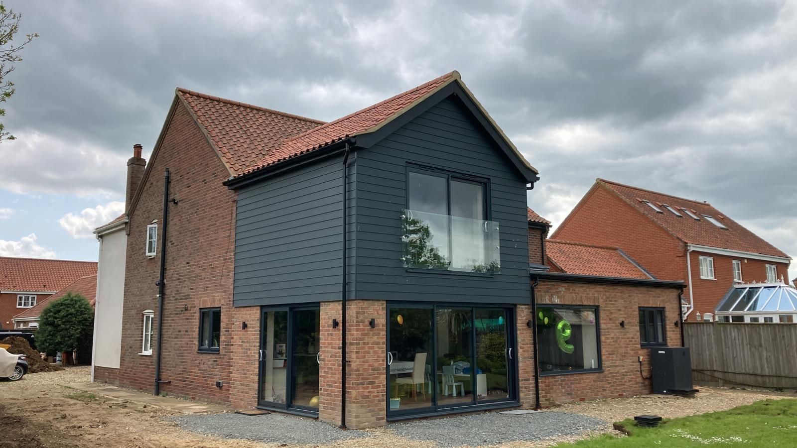 A large brick house with a black roof and a lot of windows.