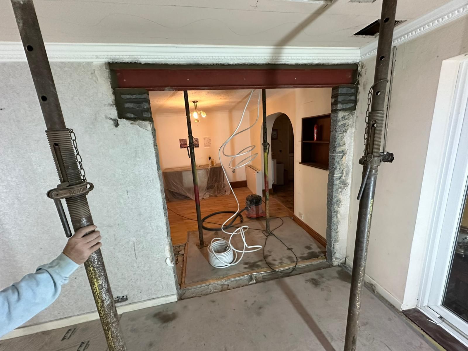 A house with a lot of windows and a gravel driveway in front of it.