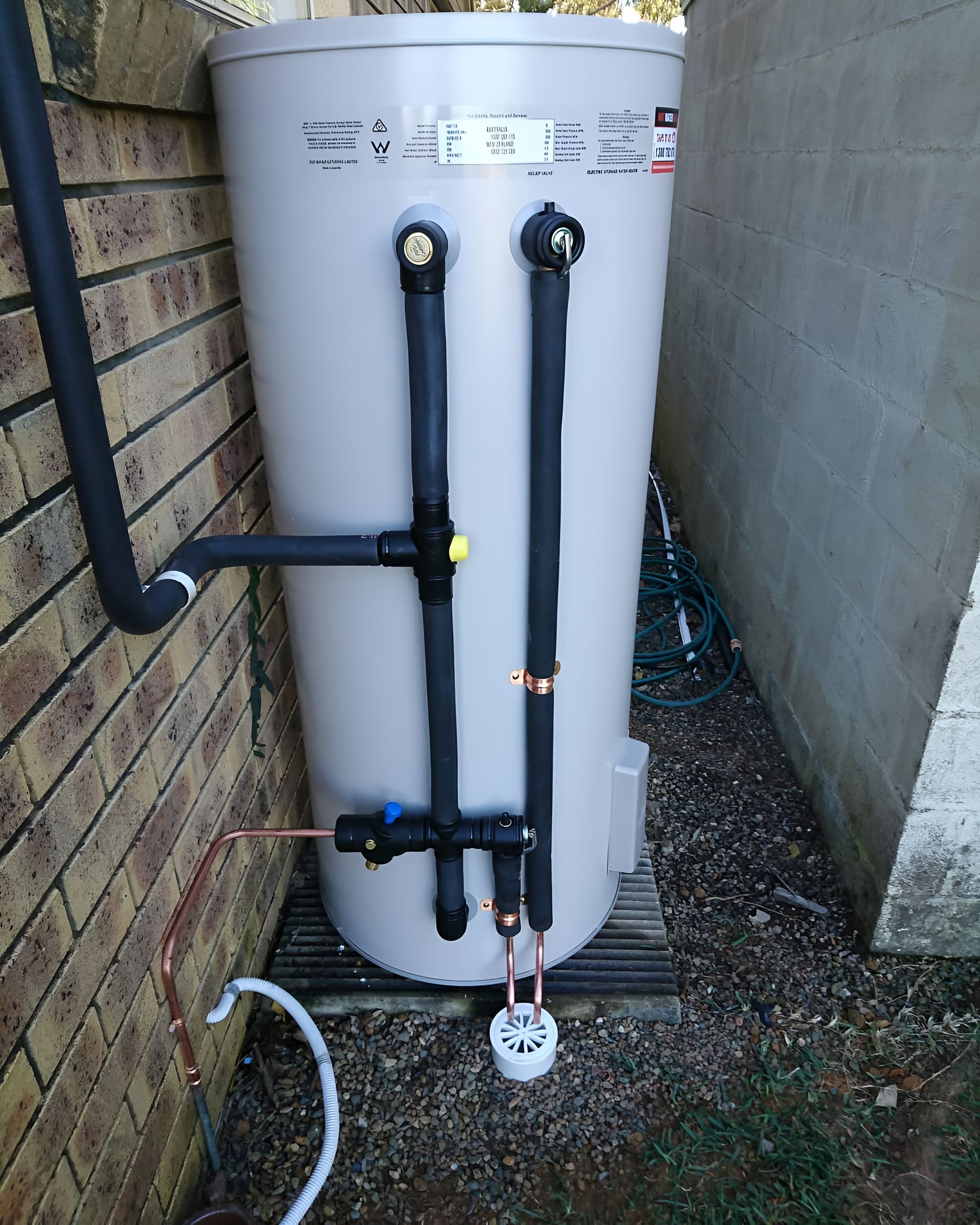 A Beige Water Heater With Black Pipes — Taps 'R' Us in Wurtulla, QLD