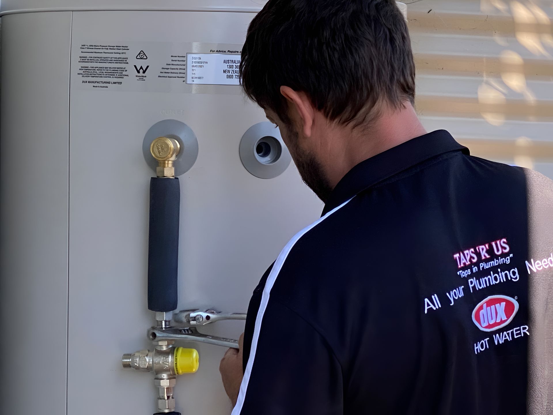 A Plumber is Working on a Water Heater — Taps 'R' Us in Kunda Park, QLD