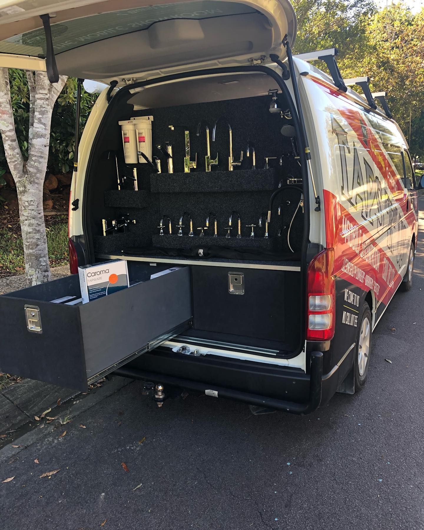A van with open back showing tools mounted on a dark panel and a drawer extended on the pavement — Taps 'R' Us in Palmwoods, QLD