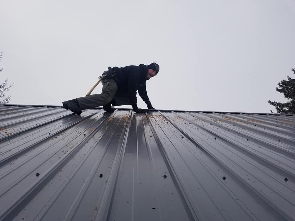 Worker on Metal Roof — Wausau, WI — CW Custom Exteriors