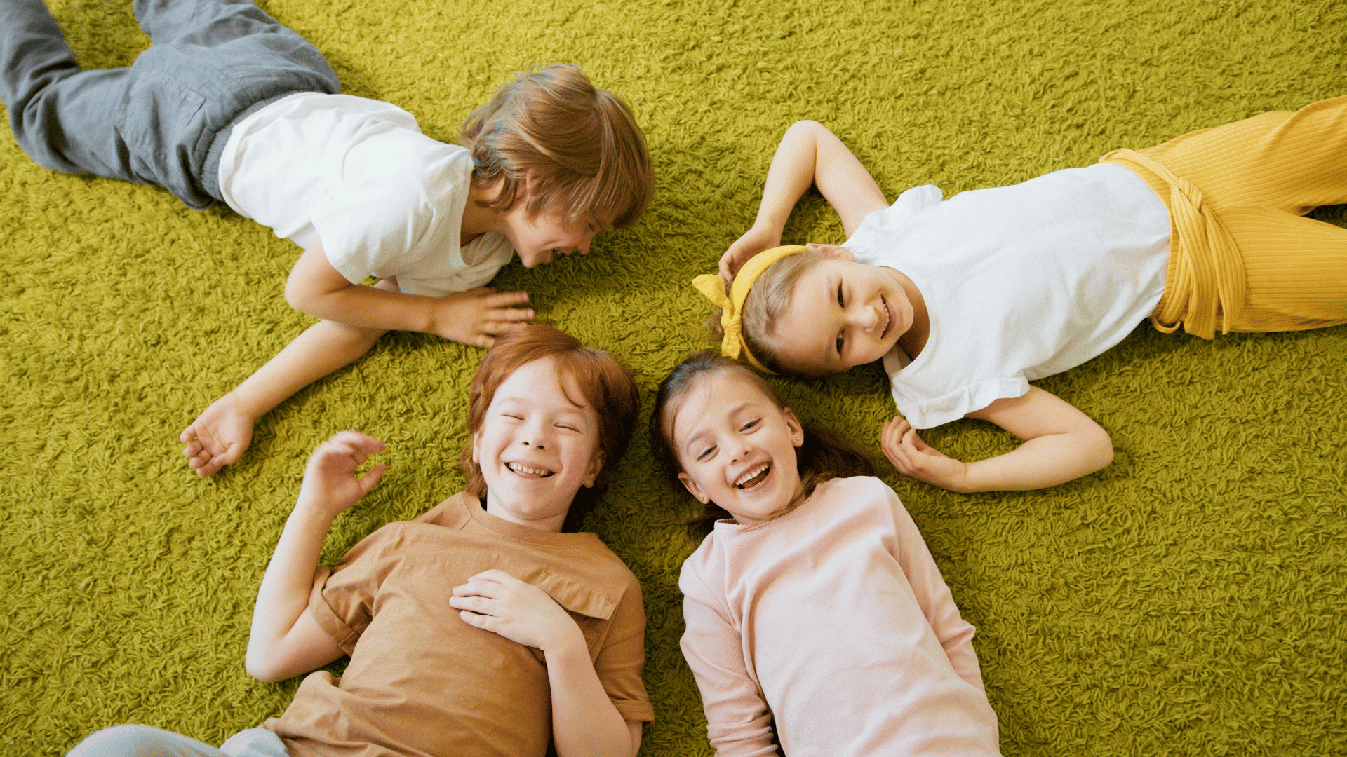 a group of children are laying on the floor in a circle .