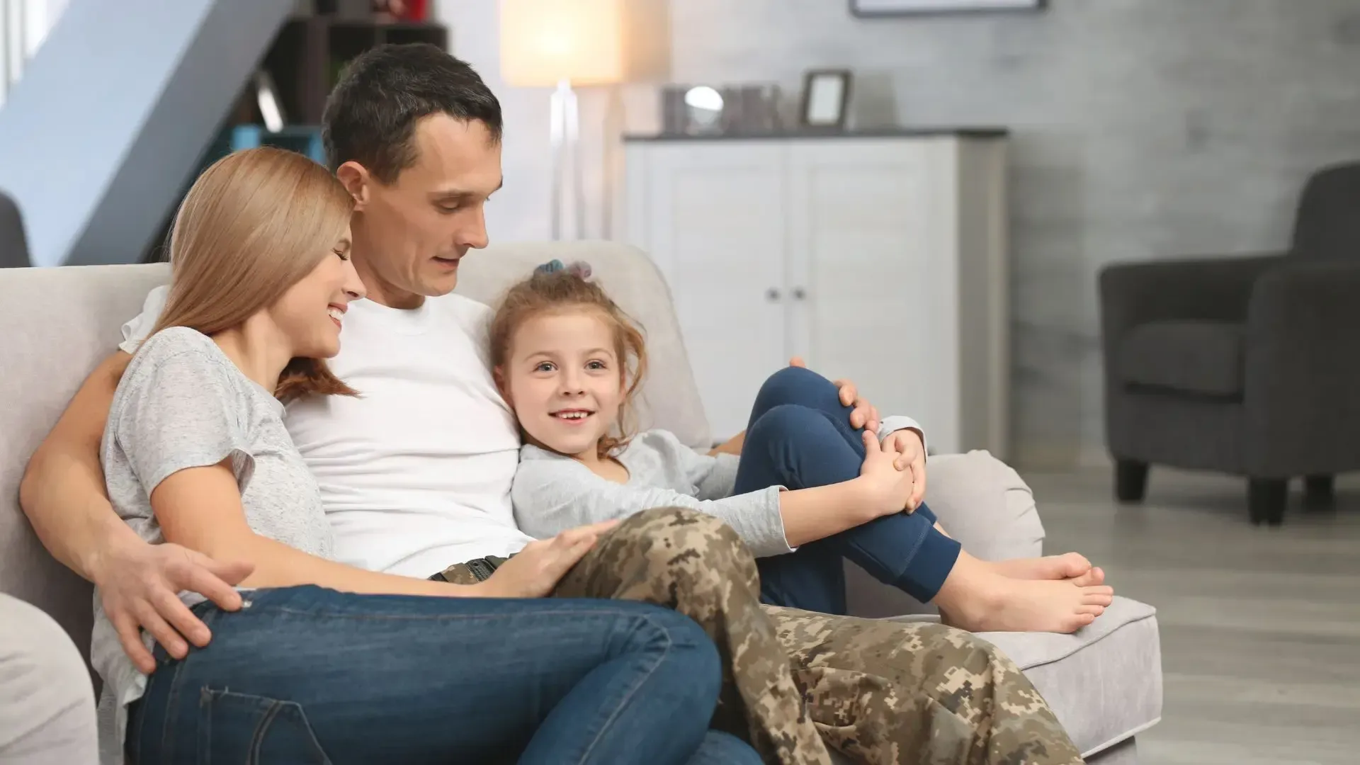 A family is sitting on a couch in a living room.
