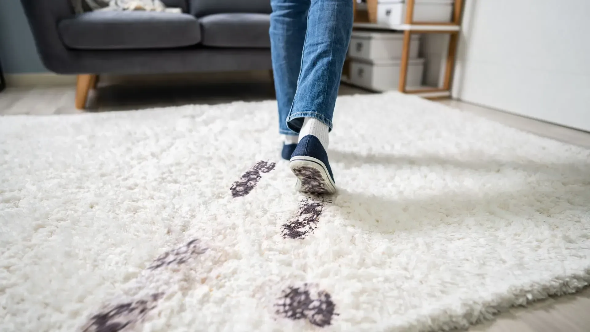 A person is walking on a dirty rug in a living room.
