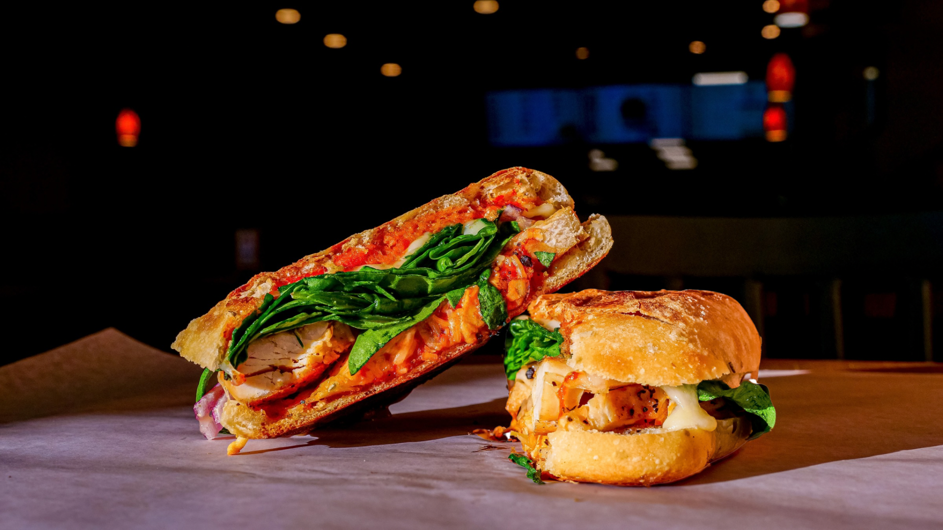 A person is holding a sandwich that has been cut in half.