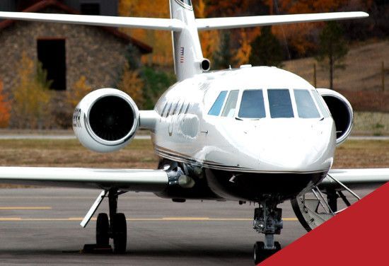 White private jet on a runway, front view with engines visible and a red corner overlay