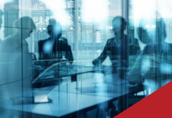 Blurred office meeting behind glass with blue tint and a red corner accent