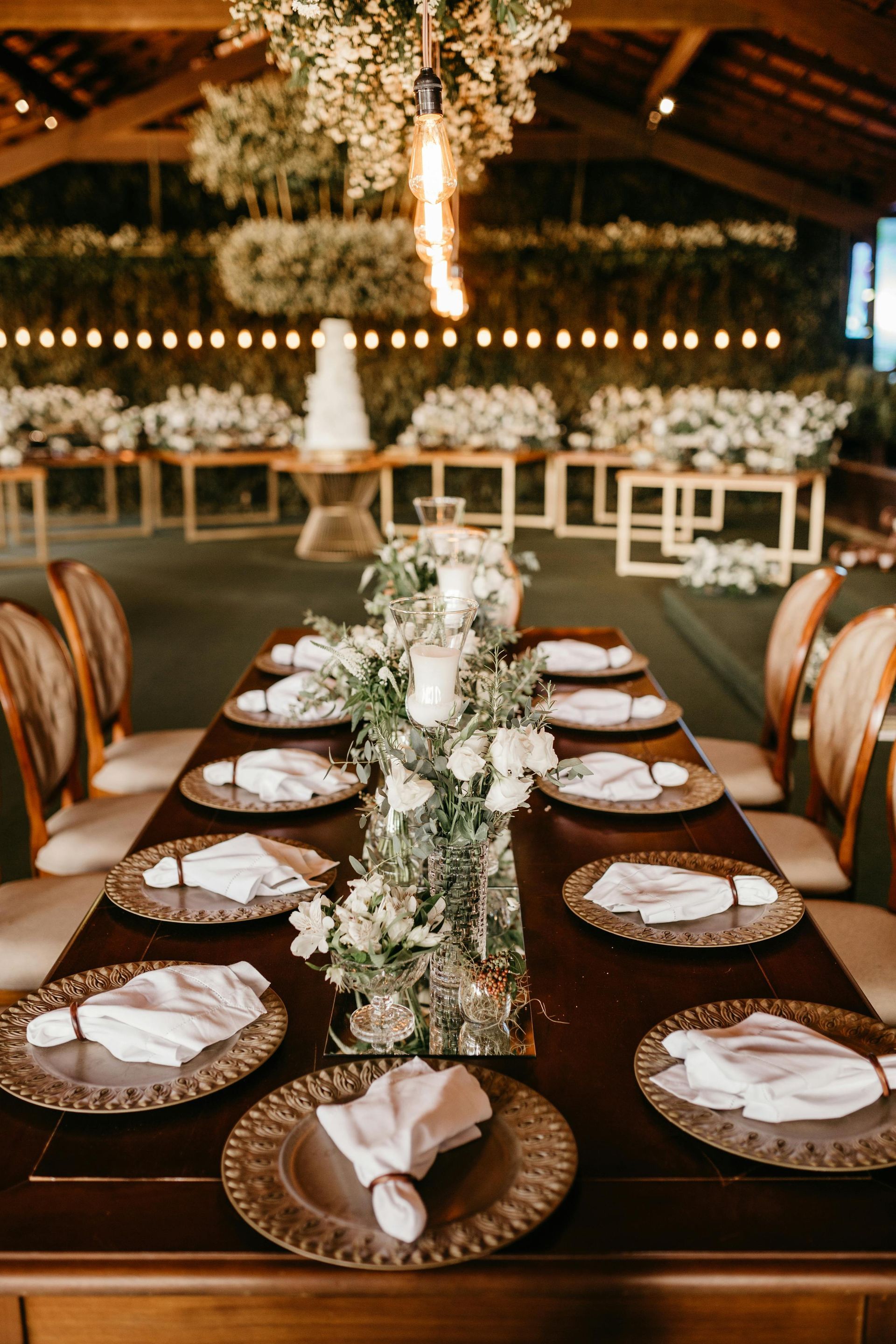 A long wooden table with plates and napkins on it.