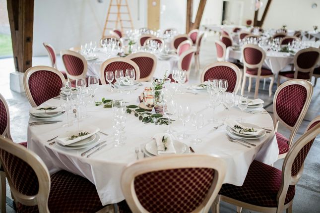 A large room with tables and chairs set up for a wedding reception.