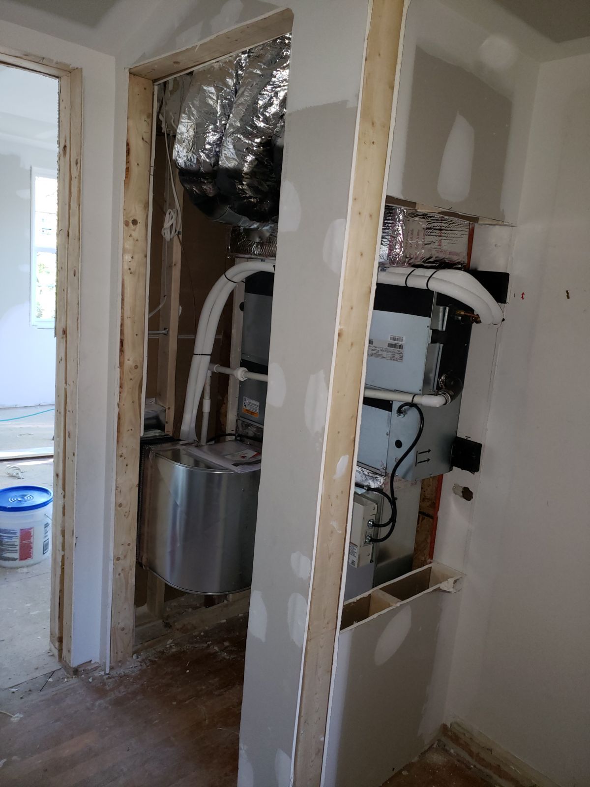 A room under construction with a washer and dryer in it.
