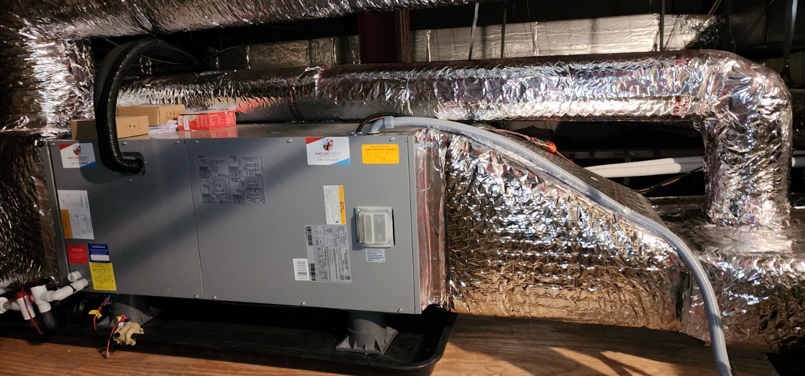 A box with a bunch of wires coming out of it is sitting on the floor in a room.