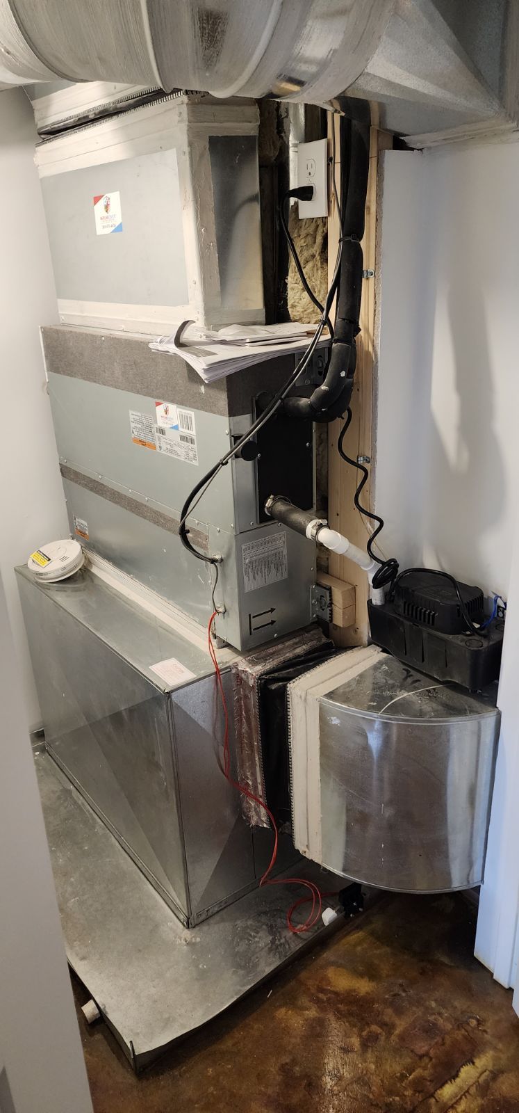 A stack of air conditioners sitting on top of each other in a room.