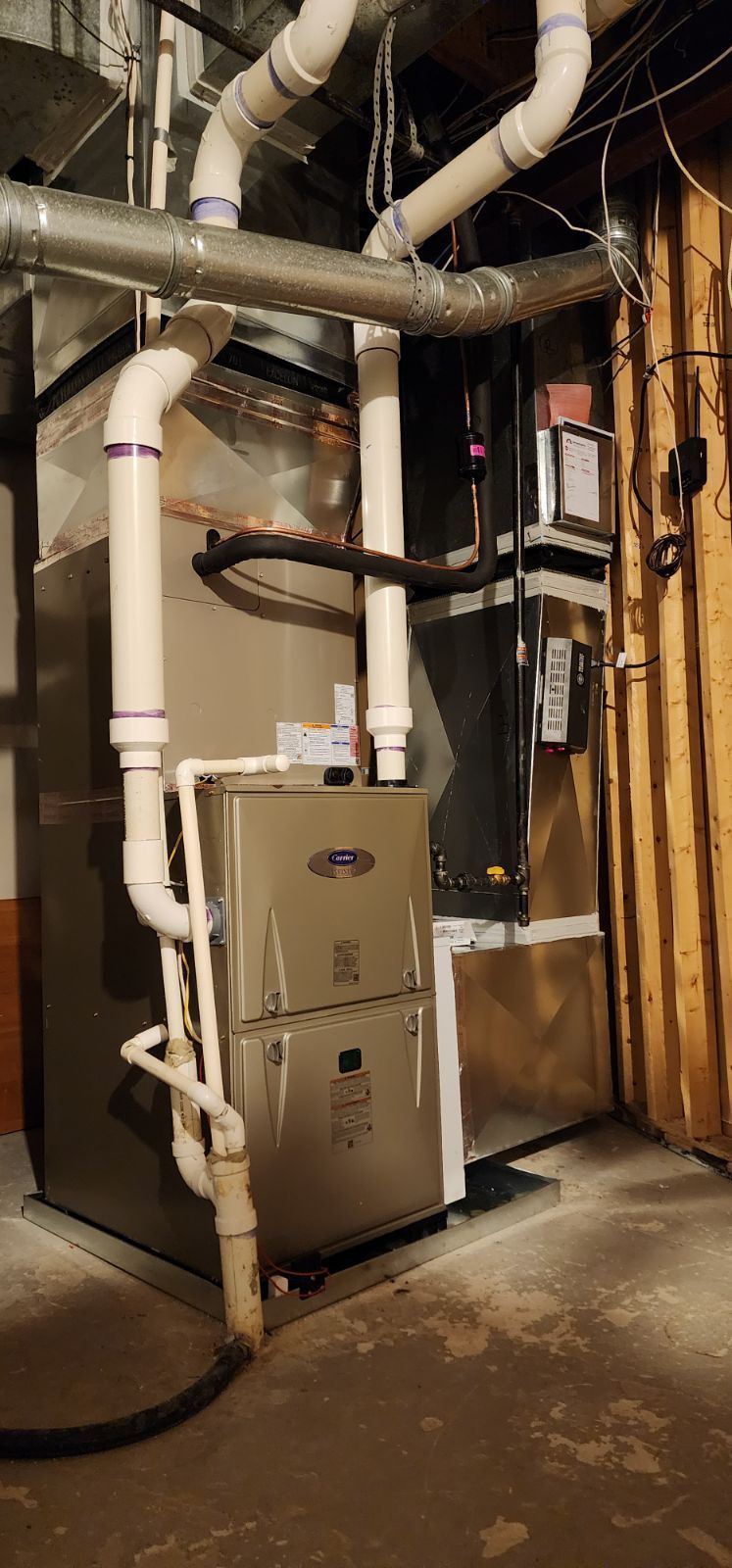 A basement with a furnace and pipes coming out of it.