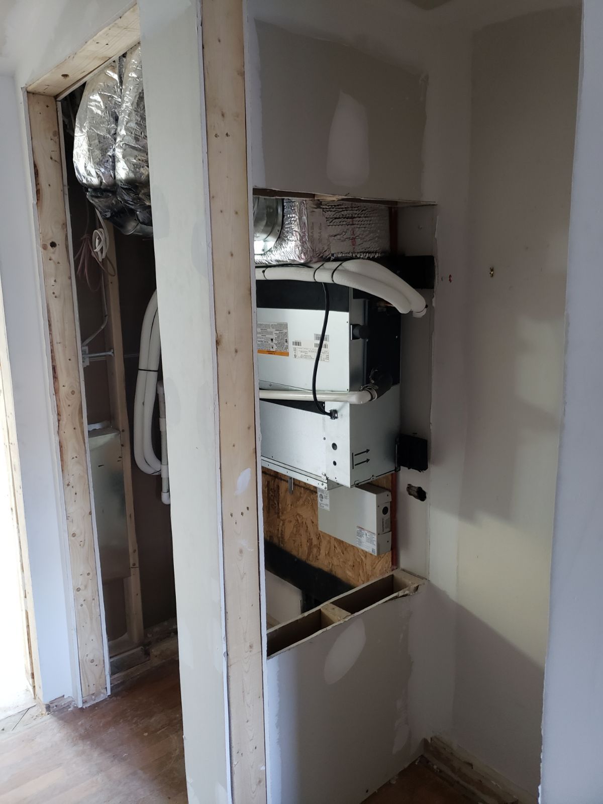 A room with a shelf and a door that is being built.