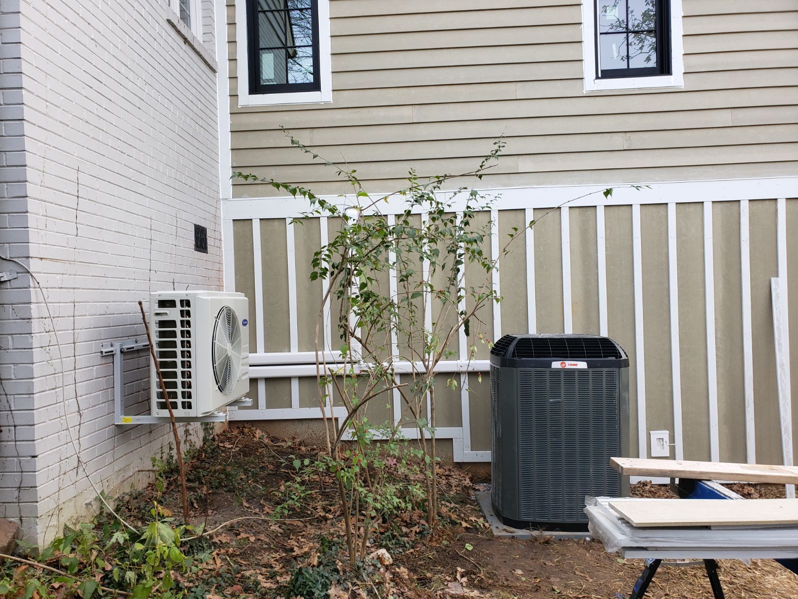A house with a air conditioner on the side of it.