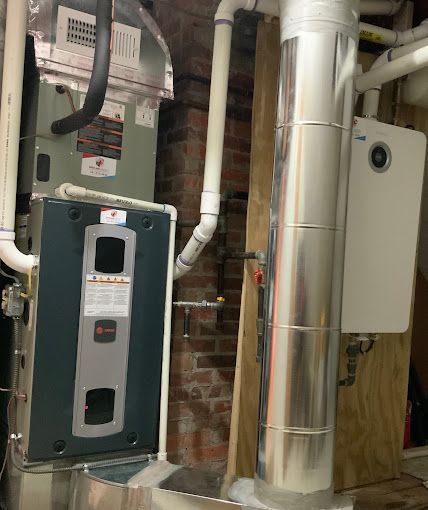 A heating and cooling system in a basement with a brick wall.