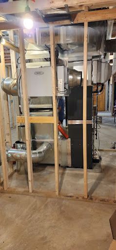 A basement with a lot of pipes and a heater.