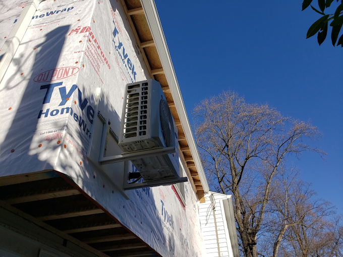 An air conditioner is mounted on the side of a building