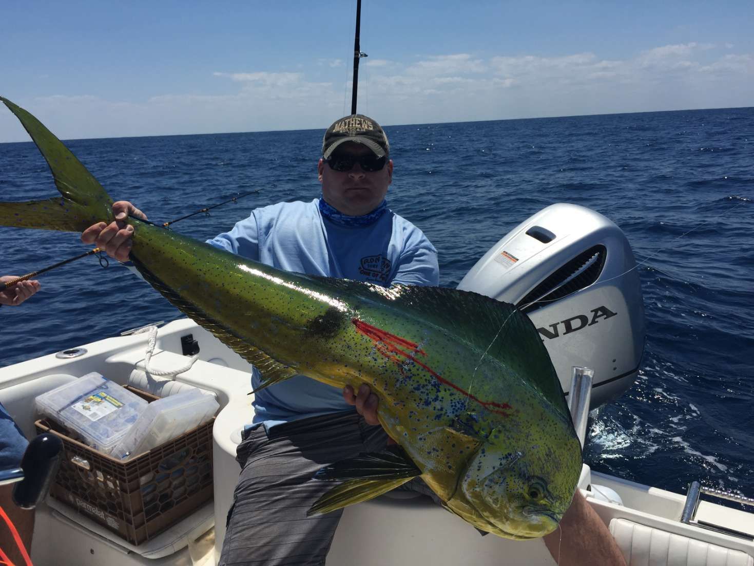 A man is holding a large fish on a boat.