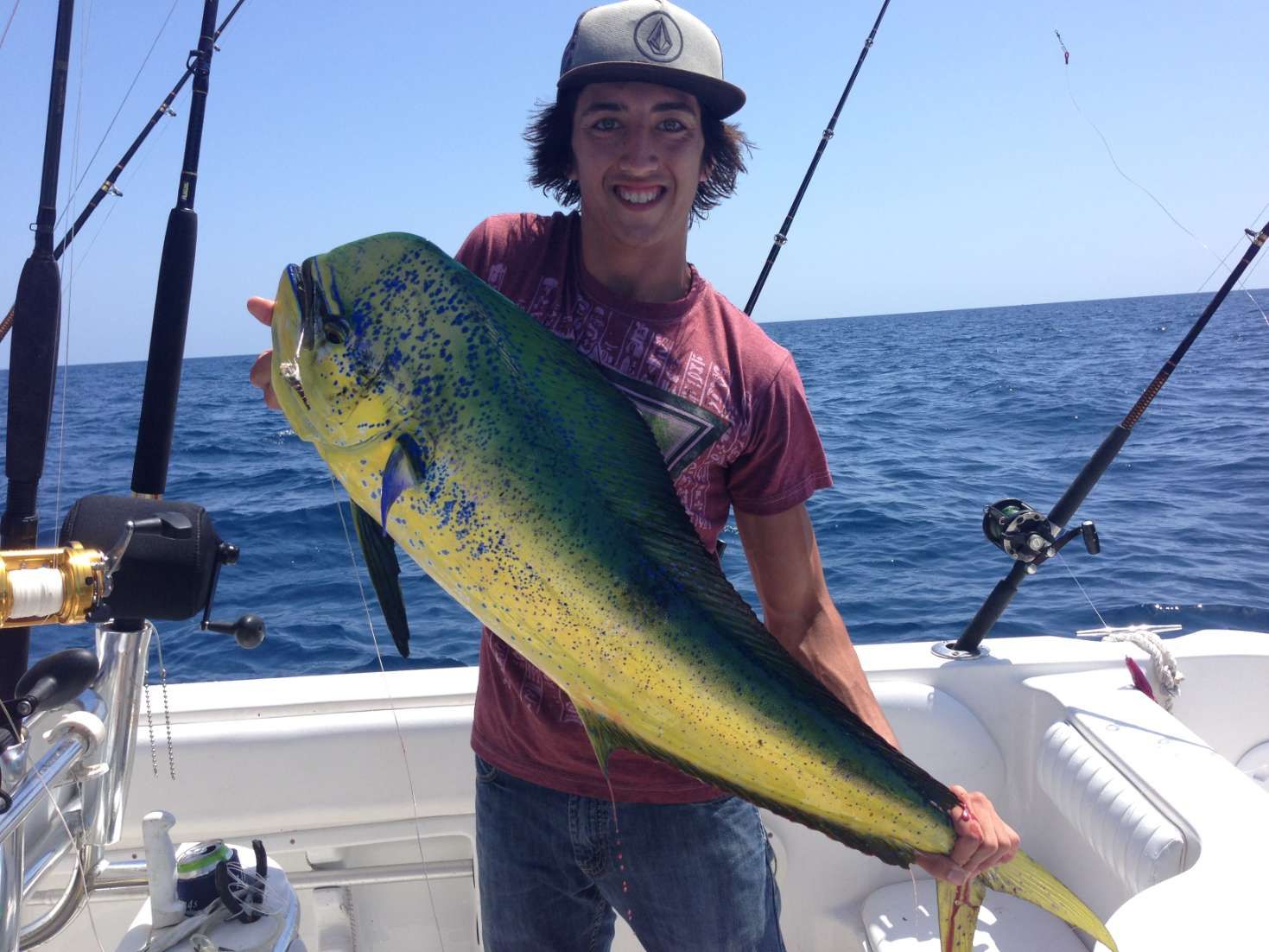 A man is holding a large fish on a boat