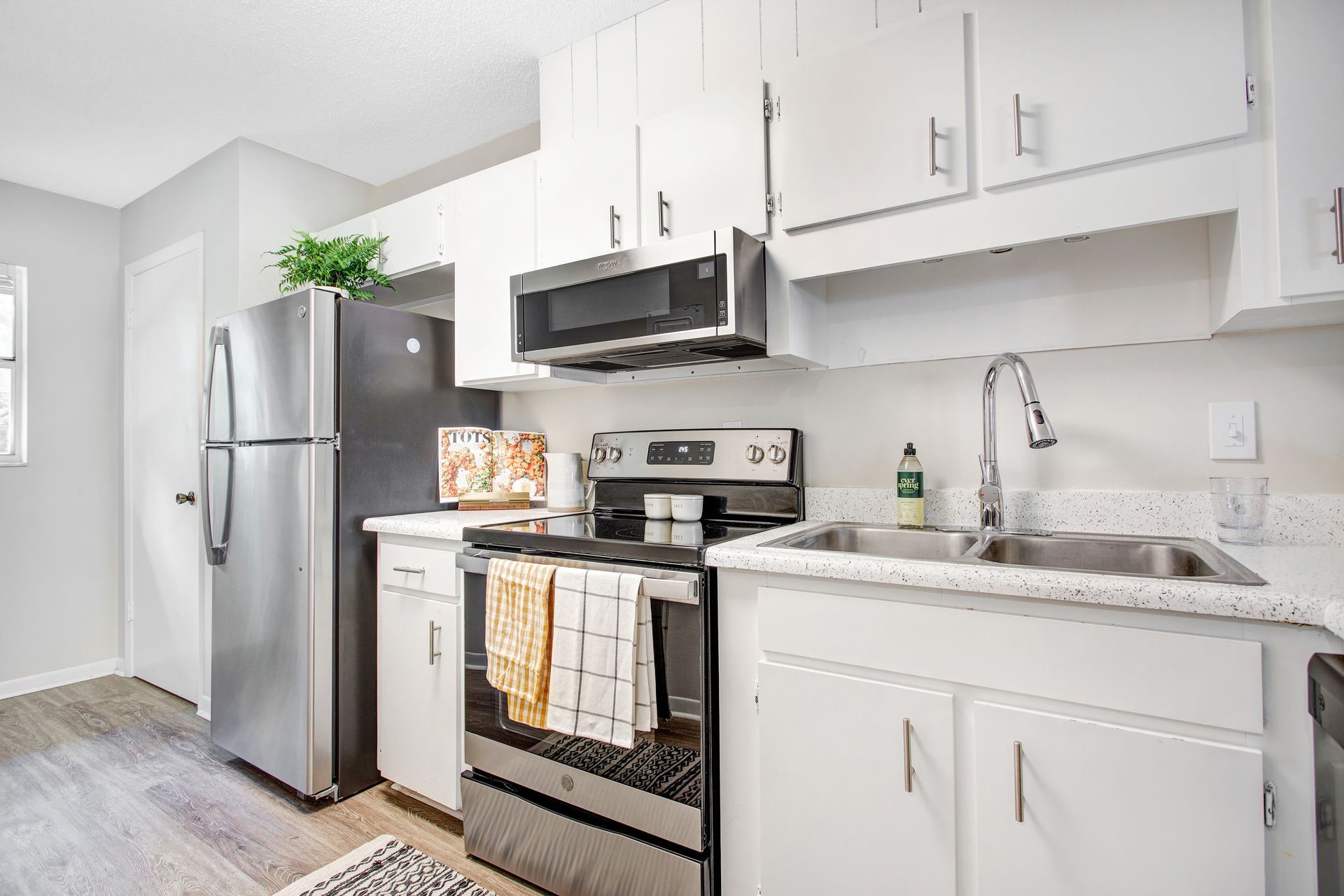A kitchen with stainless steel appliances and white cabinets.