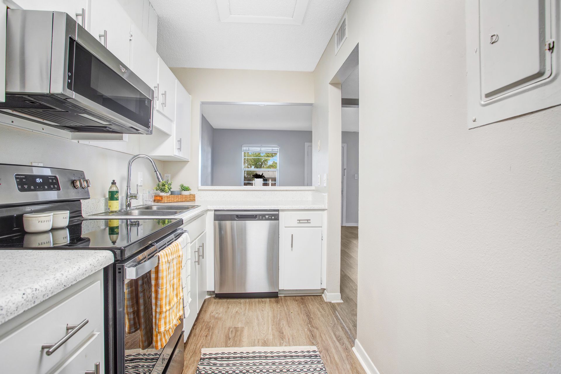 A kitchen with stainless steel appliances and white cabinets.