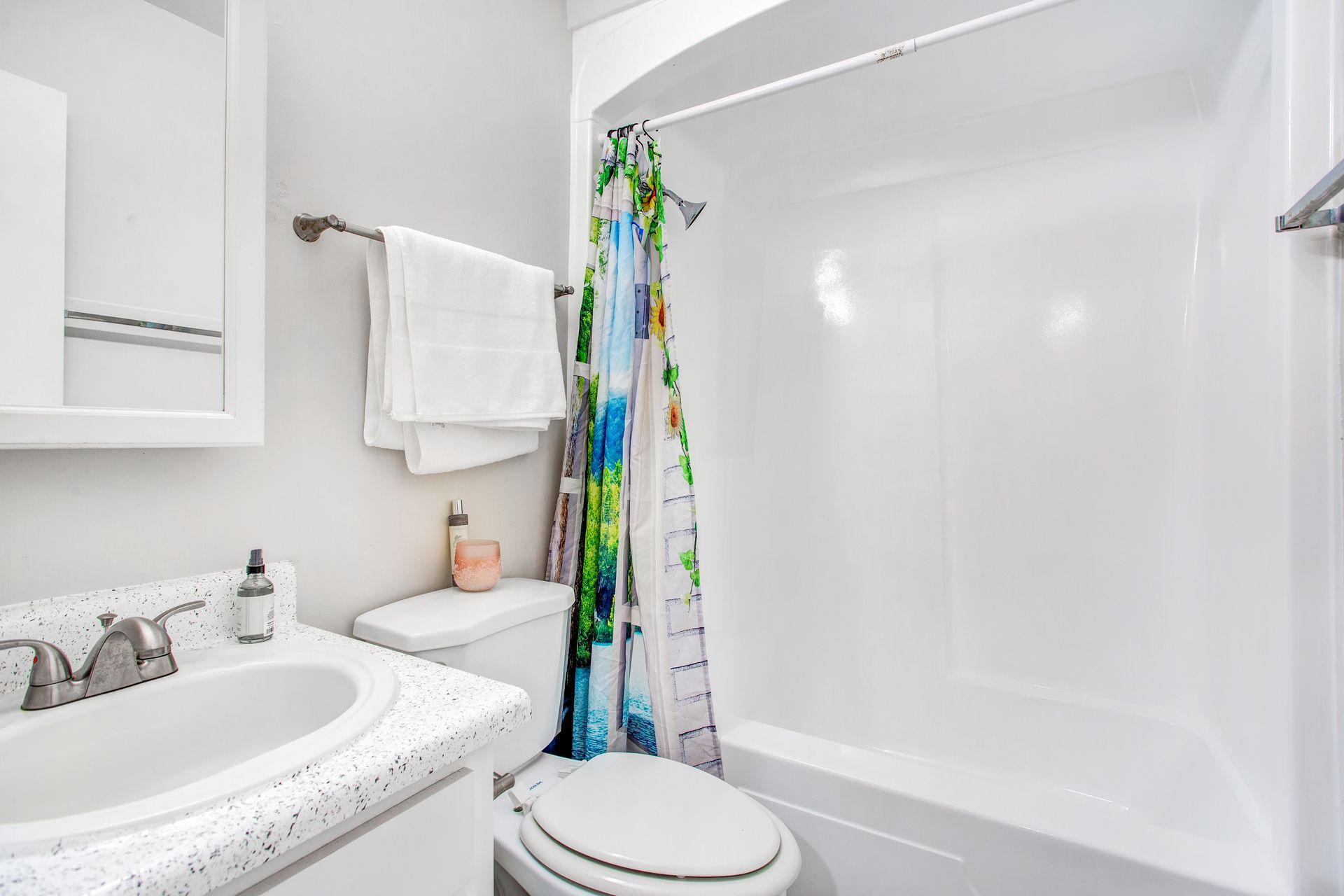 A bathroom with a toilet , sink , shower and bathtub.